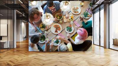 Top view of six casual friends sitting by wooden table served for dinner, enjoying meal and having chat Wall mural