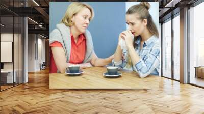 Woman supporting her friend while drinking coffee Wall mural