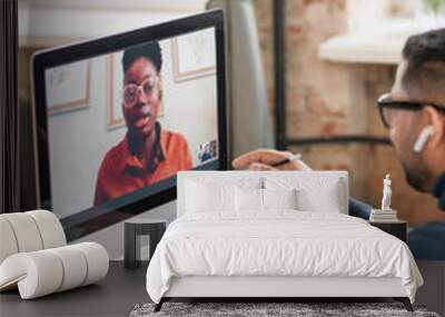 Young confident African woman on computer screen talking to male teacher during online lesson or consultation Wall mural