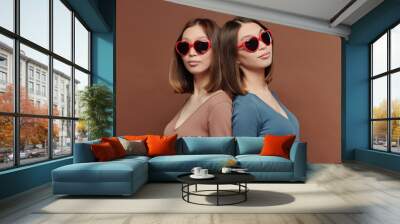 Young gorgeous twin sisters of Asian ethnicity in heartshaped sunglasses Wall mural