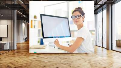 young professional designer looking at you while sitting by desk in front of computer screen Wall mural