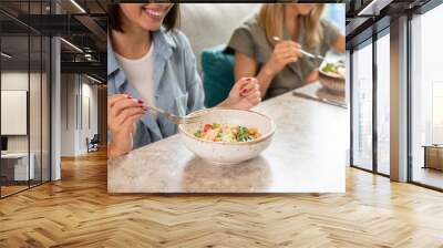 Young smiling female client of cafe or restaurant holding fork over salad Wall mural