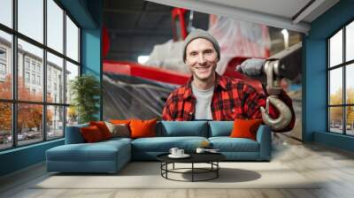 Young successful shipbuilding engineer in workwear holding by detail of large machine Wall mural