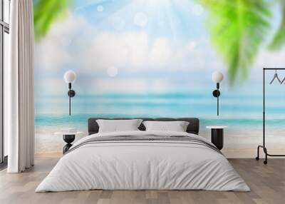 Blurred blue sky and sea with bokeh light and leaves of coconut palm tree. Wall mural