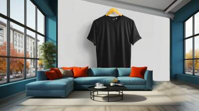 Blank black t-shirt mockup on a wooden hanger against a clean wall background Wall mural