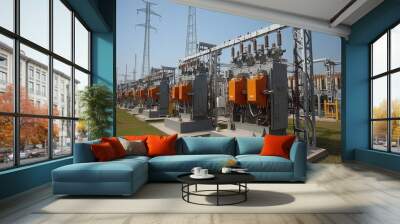 High-voltage electrical substation with transformers, power lines, and equipment under clear blue sky. Wall mural