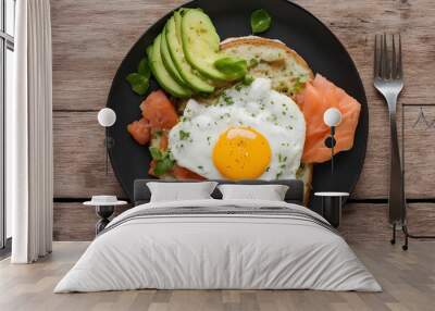 Top view of fried egg, avocado, smoke salmon toast on wooden table Wall mural