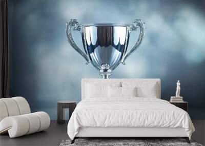 A silver trophy cup standing against a glossy silver background, representing achievement, success, and celebration of victory. Wall mural