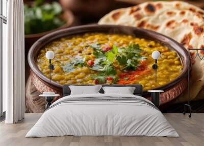 A steaming bowl of Indian dal with fresh naan bread on the side, bursting with spices and garnished with fresh herbs. Wall mural