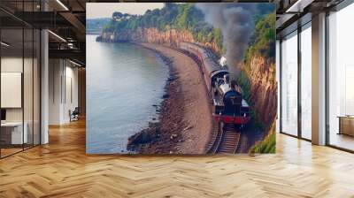 Coastal cliffs and the sea frame a historic black and red steam train as it travels along the Torquay coast, embodying picturesque heritage. Wall mural