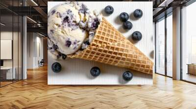 Popular fruit-flavored ice cream in a waffle cone with blueberries sprinkled around, top-down shot on a clean white background. Wall mural