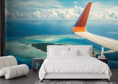 Aerial view of a tropical island with blue waters, taken from an airplane window showing the wing and island scenery below. Wall mural