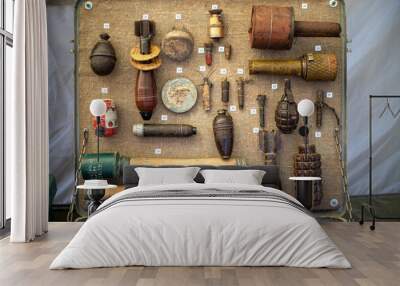 A collection of old weapons and explosives are displayed in a wooden box Wall mural