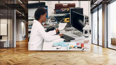 Scientist african american woman working in laboratory with computer and typing scientific text. Research and development of electronic devices by color black woman. Wall mural