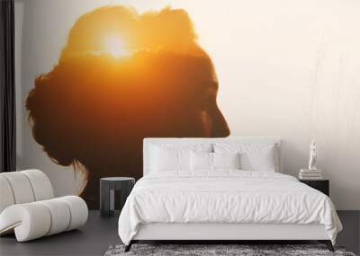 Woman with sunset and clouds beyond her head. Self-restraint and self-improvement concept. Wall mural