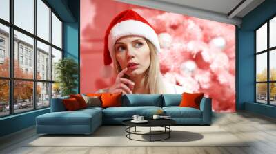 young beautiful female in red new year hat and tree Wall mural