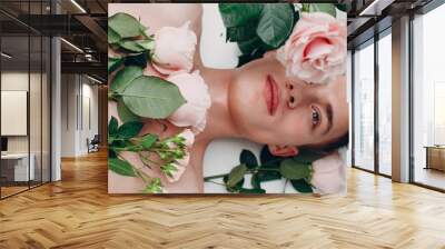 Young male model with flowers. Beauty portrait. Wall mural