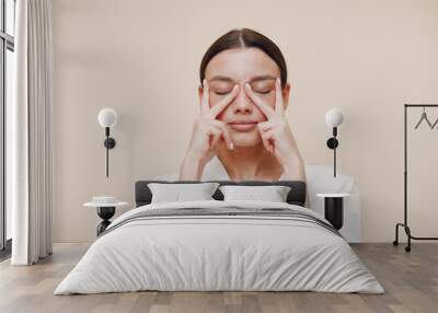 Young woman doing face building facial gymnastics self massage and rejuvenating exercises Wall mural