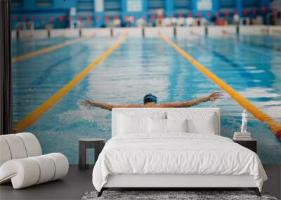 Young woman swimmer swims in swimming pool Wall mural