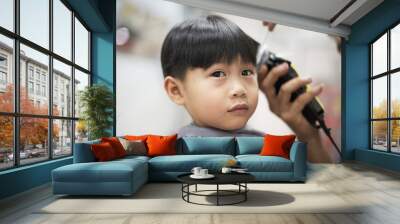 little asian boy having a haircut at barbershop : close up Wall mural