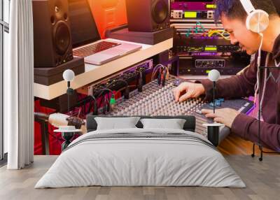 asian professional music producer working on audio mixing console in recording, broadcasting studio  Wall mural