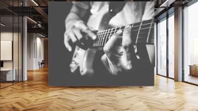 closeup male musician hands playing electric guitar on stage + bw film filter Wall mural