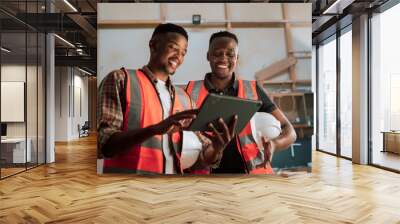 African factory workers discussing maintenance on digital tablet Wall mural