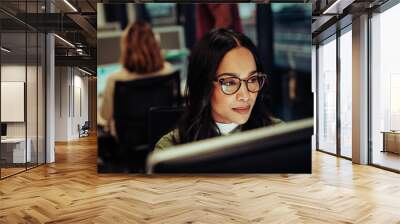 Portrait of mixed race woman working on business report typing on desktop sitting in office block Wall mural