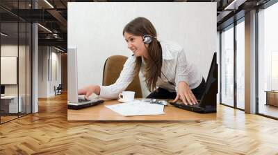 young businesswoman at the desk with two laptops Wall mural