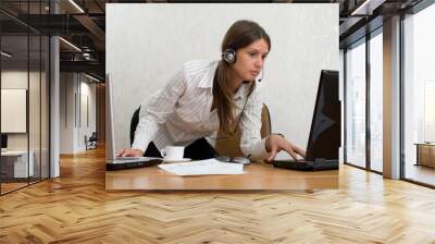 Young businesswoman in the office with two laptops Wall mural