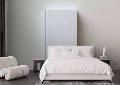 Blank white book lying on a light grey table in natural daylight. Wall mural