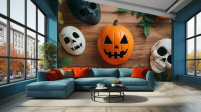 Halloween decorations featuring a carved pumpkin and skull masks on a wooden surface with green leaves. Wall mural