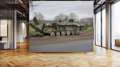 Military armored vehicles on the road. Army armored car blown up. War in Ukraine. Wall mural