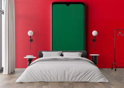 A black smartphone with a green screen sits on a red background.  It's a great mockup for app design or online content. Wall mural