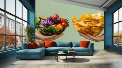 Two hands hold out bowls of healthy salad and salty chips, a choice between healthy and indulgent snacking. Wall mural