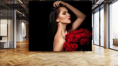 beautiful young woman with a large bouquet of red roses Wall mural