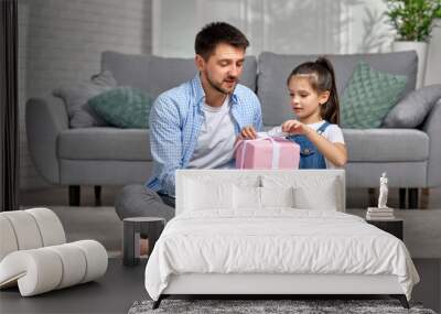 daughter congratulates father and gives him gift box. Wall mural