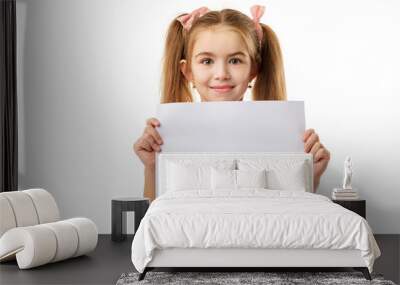 Happy cute child holding empty blank isolated on white background. kid with placard board for your text. girl with white sheet of paper. copy space Wall mural