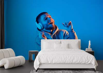 man with headphones in sweatshirt enjoying favorite music Wall mural