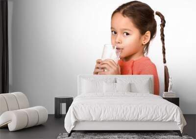 Portrait of cute little child girl drinking fresh milk isolated on white Wall mural