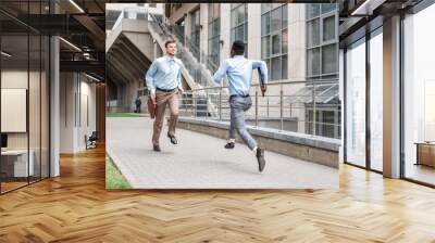 two businessmen running to meet each other Wall mural