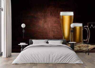 two glasses of cold golden beer and wheat spikelets on dark background. copy space Wall mural