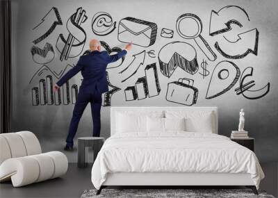 Businessman in front of a wall writing on hand drawn business interface - business concept Wall mural