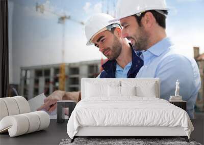 Engineer and worker watching blueprint on construction site Wall mural