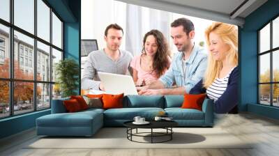 Group of 4 young attractive people working on a laptop Wall mural