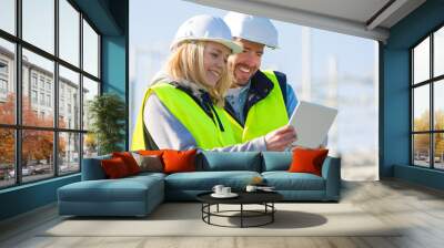 Two workers working outside with a tablet on a construction site Wall mural