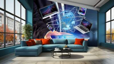 View of a Businessman holding a Computer and devices displayed on a smartphone interface with international network  - 3d render Wall mural