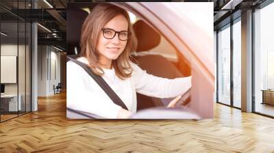 Young attractive woman driving his car Wall mural