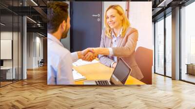 young attractive woman handshaking at the end of a job interview Wall mural