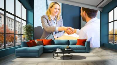 young attractive woman handshaking at the end of a job interview Wall mural